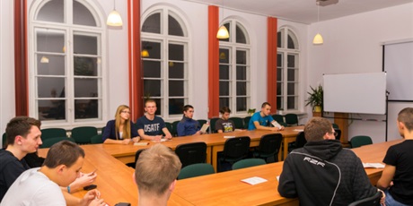Powiększ grafikę: Wychowankowie siedzą przy stołach w sali konferencyjnej budynku przy ul. Podwale Staromiejskie.